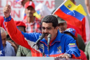 Aposta da Polymarket Maduro resultando em saque de US$ 400.000 Nicolas Maduro com uma camisa azul, vermelha e branca, dirigindo-se a uma multidão atrás de um pódio. Aposta da Polymarket Maduro resultando em saque de US$ 400.000 desperta preocupações sobre uso de informações privilegiadas