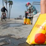 Vítimas de arraias sentam-se para tomar banho de água quente após serem atingidas por arraias na segunda-feira, 12 de janeiro de 2026, na Praia Estadual Bolsa Chica. (Foto cortesia de Laurie Haller)