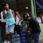 CARACAS, VENEZUELA - 03 DE JANEIRO: Pessoas compram água engarrafada depois que explosões e aeronaves voando baixo foram ouvidas na madrugada de 3 de janeiro de 2026 em Caracas, Venezuela. Segundo alguns relatos, explosões foram ouvidas em Caracas e outras cidades próximas a aeroportos e bases militares por volta das 2h. O presidente dos EUA, Donald Trump, anunciou mais tarde que os militares do seu país lançaram uma campanha