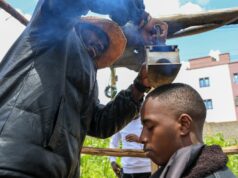 Barbeiro queniano que empunha uma pá afiada prospera com a febre da mídia social na África O barbeiro e criador de conteúdo viral Safari Martins demonstra um de seus métodos inventivos de barbear usando uma caixa de ferro enquanto prepara Ian Njenga em Kiambu, Quênia, quarta-feira, 26 de novembro de 2025. (AP Photo / Andrew Kasuku)