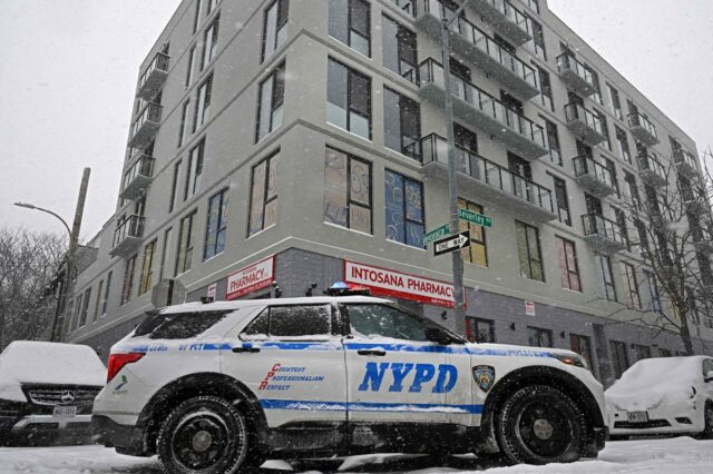 Bebê recém-nascido é encontrado morto no apartamento da mãe em Um carro da polícia de Nova York estacionado em uma rua coberta de neve ao lado de um prédio com uma farmácia no térreo.