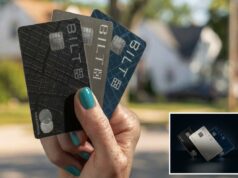 Bilt lança três cartões de crédito com TAEG de 10% por 12 meses depois que o presidente Trump pede um limite Uma mão segurando três cartões de crédito Bilt em preto, prata e azul, contra um fundo suburbano desfocado.