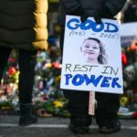 Uma pessoa segurando uma placa lendo