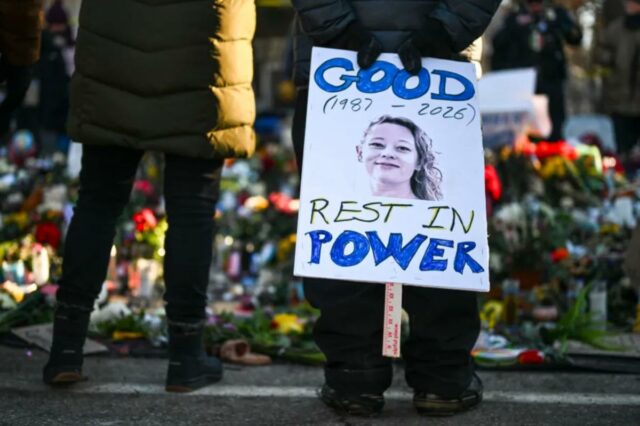 Uma pessoa segurando uma placa lendo 