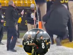 Campo do Steelers abençoado por padre antes da emocionante vitória nos playoffs sobre o Ravens Um homem com uma camisa preta de mangas compridas está agachado em um campo de futebol americano, tocando a linha lateral amarela com a mão, enquanto três homens estão ao seu redor, um deles segurando uma longa vara de madeira.