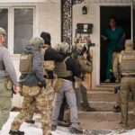 Agentes federais estão do lado de fora de uma loja de conveniência na quarta-feira, 21 de janeiro de 2026, em Minneapolis. (Foto AP/Angelina Katsanis)