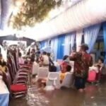 Casal de noivos no oeste de Jacarta está desesperado para enfrentar enchentes para realizar uma recepção de casamento