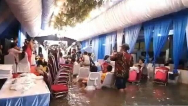 Casal de noivos no oeste de Jacarta está desesperado para enfrentar enchentes para realizar uma recepção de casamento
