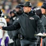 O técnico do Baltimore Ravens, John Harbaugh, está na linha lateral.