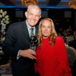 Jim McIngvale, proprietário da Gallery Furniture, conversando em um balcão de sua loja, com uma placa que diz