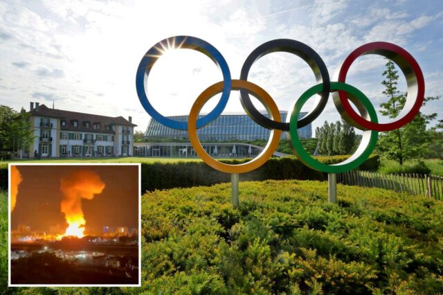 A escultura dos anéis olímpicos com a sede do COI ao fundo.
