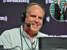 Como a 33ª equipe de Mike Tannenbaum está influenciando a NFL nos bastidores e nos dias de jogo Um homem usando um fone de ouvido e uma jaqueta de cor clara sorri diante de um fundo com o logotipo SiriusXM.
