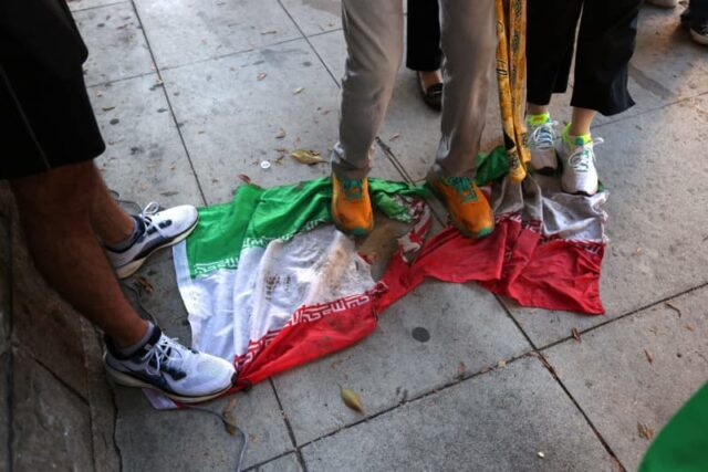 Iranianos se reúnem enquanto bloqueiam uma rua durante um protesto em Teerã, Irã, em 9 de janeiro de 2026. Os protestos em todo o país começaram no Grande Bazar de Teerã contra as políticas econômicas fracassadas no final de dezembro, que se espalharam por universidades e outras cidades (crédito: MAHSA/Middle East Images/AFP via Getty Images)