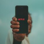 O vídeo vertical da Netflix chegará este ano | Uma mão segurando um smartphone verticalmente com o logotipo da Netflix