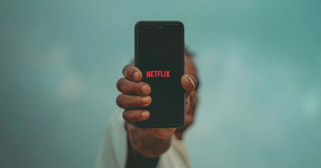 O vídeo vertical da Netflix chegará este ano | Uma mão segurando um smartphone verticalmente com o logotipo da Netflix