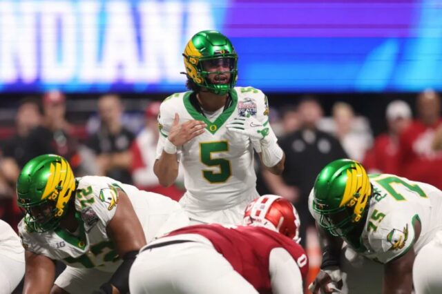 Dante Moore ainda não tomou a decisão do draft da O quarterback do Oregon Ducks, Dante Moore (5), convoca uma jogada na linha de scrimmage contra o Indiana Hoosiers durante o primeiro quarto do Peach Bowl de 2025 e o jogo semifinal do College Football Playoff no Mercedes-Benz Stadium.