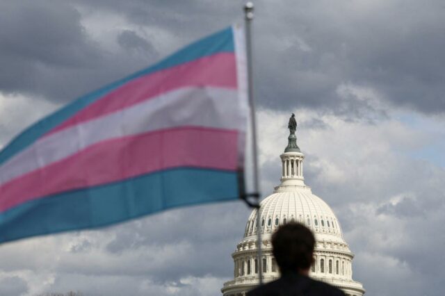Uma bandeira transgênero tremulando em frente à cúpula do Capitólio dos EUA.
