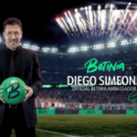Diego Simeone anunciado como novo embaixador da Betinia. Diego Simeone segurando uma bola de futebol verde do Betinia no estádio, anunciado como embaixador oficial do Betinia com fogos de artifício ao fundo.