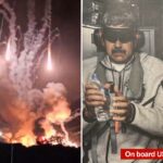 Um homem de bigode, vendado, fones de ouvido, moletom com capuz cinza e calça de moletom cinza, segurando uma garrafa de água.