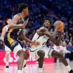 Drake Powell (4) pretende arremessar contra o pivô do New Orleans Pelicans, Yves Missi (21), no segundo tempo de um jogo de basquete da NBA, quarta-feira, 14 de janeiro de 2026, em Nova Orleans.
