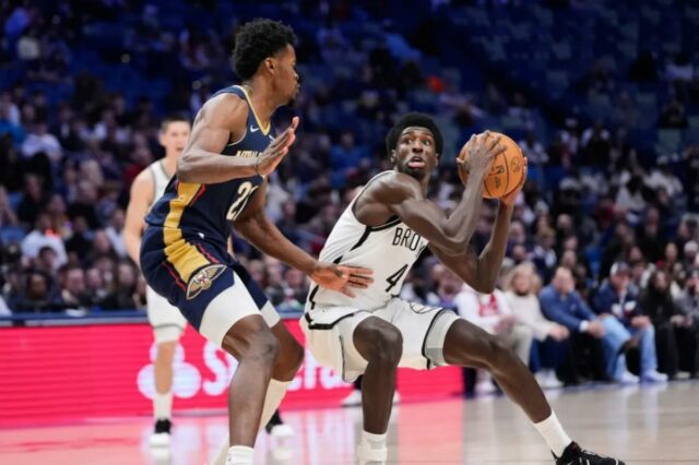 Drake Powell (4) pretende arremessar contra o pivô do New Orleans Pelicans, Yves Missi (21), no segundo tempo de um jogo de basquete da NBA, quarta-feira, 14 de janeiro de 2026, em Nova Orleans. 