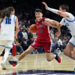 Dylan Darling, do St. John, passa a bola por Filip Borovicanin, do Xavier.