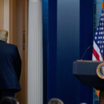 Um menino segura um mapa riscado da Groenlândia encimado por uma peruca simbolizando o presidente dos EUA, Donald Trump, durante um protesto contra a política de Trump em relação à Groenlândia em frente ao consulado dos EUA em Nuuk, Groenlândia, sábado, 17 de janeiro de 2026. (AP Photo/Evgeniy Maloletka)