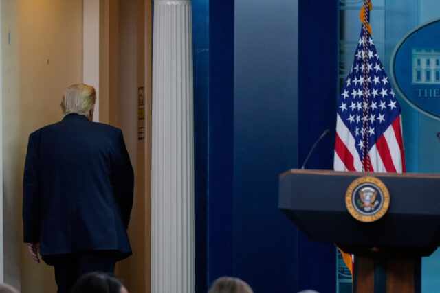 Um menino segura um mapa riscado da Groenlândia encimado por uma peruca simbolizando o presidente dos EUA, Donald Trump, durante um protesto contra a política de Trump em relação à Groenlândia em frente ao consulado dos EUA em Nuuk, Groenlândia, sábado, 17 de janeiro de 2026. (AP Photo/Evgeniy Maloletka)