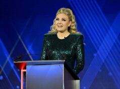 Erika Kirk eviscera o Washington Post por críticas sobre seu guarda-roupa e diz ao jornal para ‘tocar a grama’ Uma mulher loira, usando um vestido verde brilhante, falando em um pódio.