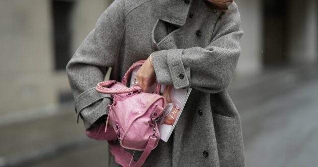 Um convidado da Fashion Week é visto usando brincos redondos de diamante, um vestido midi preto de mangas compridas com padrão de bolinhas brancas, lapelas entalhadas e um cinto de gravata; uma pulseira de ouro; um relógio em ouro rosa e preto da Rolex; um anel de ouro; uma bolsa preta retangular com padrão de bolinhas brancas; e sapatos pretos pontiagudos, também com padrão de bolinhas brancas, antes do desfile Elie Saab Womenswear Primavera/Verão 2025 como parte da Paris Fashion Week em 28 de setembro de 2024 em Paris, França.