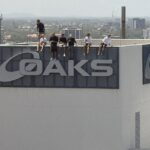 Um grupo de oito meninos é visto se equilibrando no topo do Oaks Gold Coast Hotel na sexta-feira