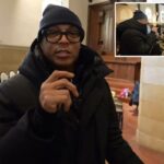 Don Lemon usando óculos e uma gola alta azul enquanto fala ao microfone.