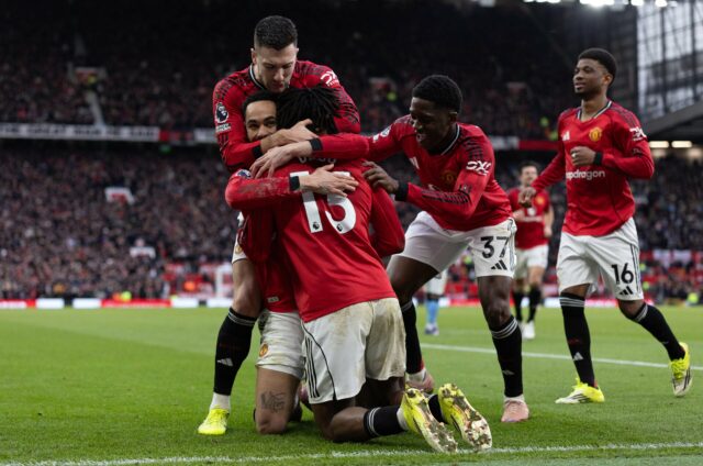 O técnico interino do Manchester United, Michael Carrick, aborda Patrick Dorgu após a partida da Premier League entre Manchester United e Manchester City em Old Trafford em 2026 em Manchester, Inglaterra.