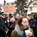 Manifestantes se reúnem na rua onde Renee Nicole Good, de 37 anos, foi baleada e morta à queima-roupa em 7 de janeiro por um agente do Departamento de Imigração e Alfândega dos EUA (ICE) enquanto ela aparentemente tentava se afastar de agentes que estavam aglomerados ao redor de seu carro, em Minneapolis, Minnesota, em 8 de janeiro de 2026.