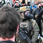 Agentes do ICE fortemente armados enfrentam manifestantes em Minnesota.