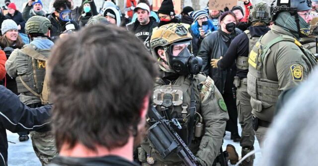 Agentes do ICE fortemente armados enfrentam manifestantes em Minnesota.