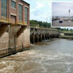 A torre de controle de tráfego aéreo do Aeroporto Internacional Hartsfield-Jackson Atlanta é vista do terminal, com vários aviões estacionados na pista.