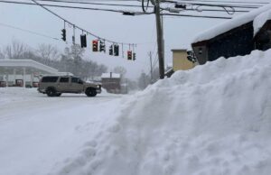 Grande tempestade de neve fazendo com que vários programas da NCAA nos EUA alterassem as programações Tráfego passa por neve acumulada em Lowville, NY