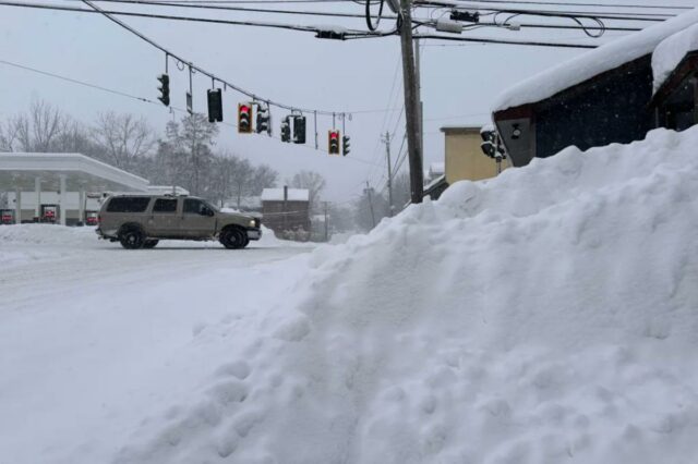 Tráfego passa por neve acumulada em Lowville, NY