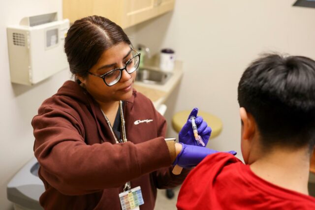 profissional de saúde dá uma injeção em uma criança
