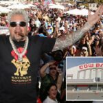 Guy Fieri posando com fãs com os braços estendidos em um evento ao ar livre.