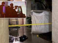 Heróico agente do ICE fora de serviço atira em atirador ativo em Los Angeles Vista do corredor de um complexo de apartamentos à noite, com fita amarela da cena do crime isolando uma área próxima a uma escada de metal e uma lona branca cobrindo uma seção do edifício.