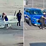 Duas pessoas ao lado de um pequeno avião branco num campo de aviação.