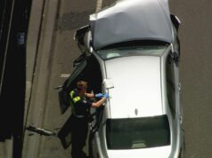 Homem é contido por transeuntes após carro bater em vários outros em estrada movimentada A frente do Camry prateado foi destruída após as colisões.