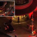 Foto aérea do Hospital Metodista Presbiteriano de Brooklyn de Nova York à noite com várias ambulâncias e carros de polícia do lado de fora.