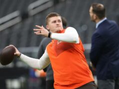 Jatos assinam contrato futuro com Bailey Zappe conforme começa a redefinição da profundidade do QB Bailey Zappe, do Cleveland Browns, se aquece, vestindo uma camisa branca de mangas compridas sob um colete laranja e segurando uma bola de futebol.