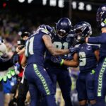 Sam Darnold #14 of the Seattle Seahawks calls a play in the huddle during the first quarter of an NFL divisional playoff football game against the San Francisco 49ers at Lumen Field on January 17, 2026 in Seattle, Washington.
