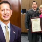 Israel Claustro e Katrina Foley segurando um documento emoldurado em um tribunal.