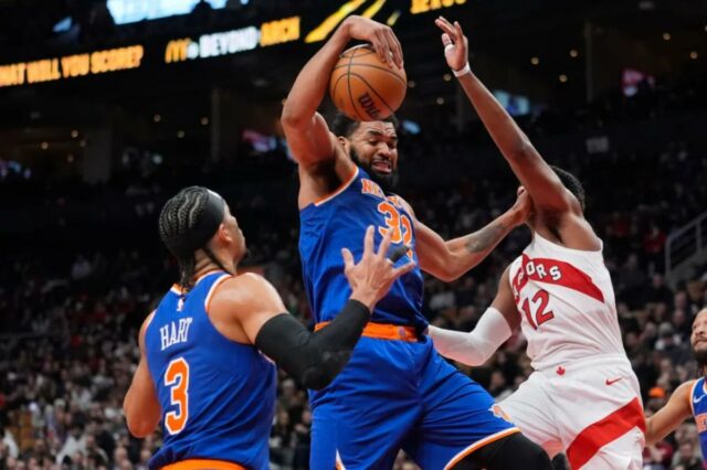 Karl-Anthony Towns pega um de seus 22 rebotes, o melhor da temporada, durante a vitória dos Knicks por 119-92 sobre os Raptors em 28 de janeiro de 2026, em Toronto.
