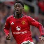 Kobbie Mainoo correndo com o uniforme do Manchester United.